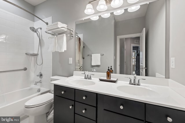 bathroom featuring washtub / shower combination, double vanity, a sink, and toilet