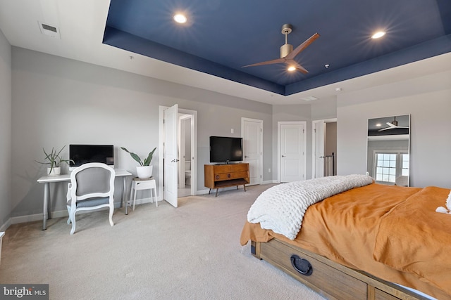 bedroom with baseboards, visible vents, a raised ceiling, and light colored carpet