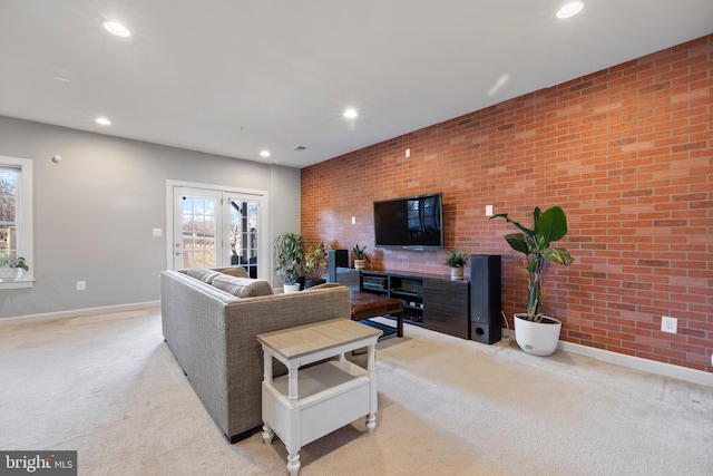 living area with light carpet, brick wall, baseboards, and recessed lighting