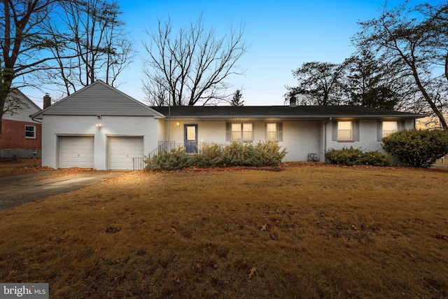 single story home featuring a garage and a front yard