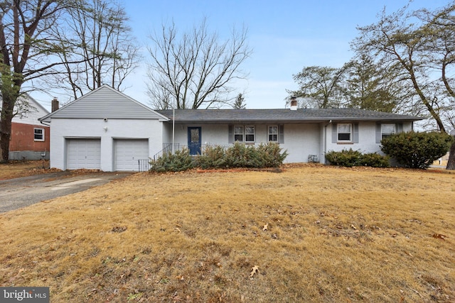 ranch-style house with a garage and a front lawn