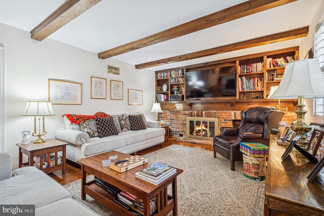 living room with a fireplace, hardwood / wood-style flooring, and beam ceiling