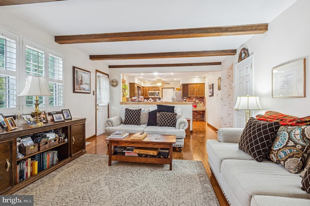 living room featuring light wood-type flooring and beam ceiling