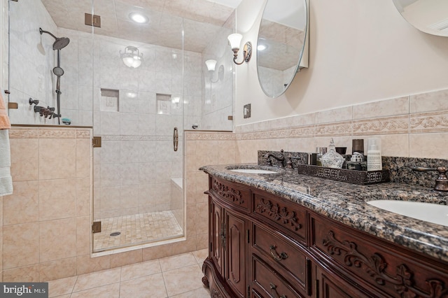 bathroom featuring tile walls, vanity, an enclosed shower, and tile patterned floors