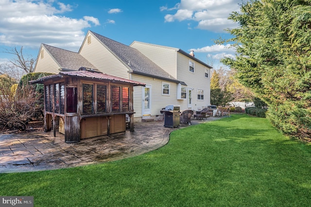 back of house with a patio, a lawn, and a sunroom