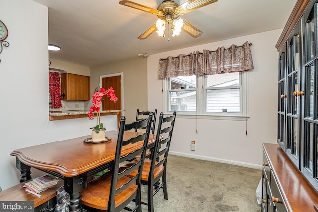 dining area featuring light carpet and ceiling fan