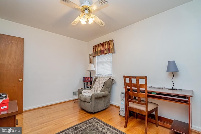 living area featuring hardwood / wood-style flooring and ceiling fan