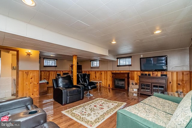 living room with hardwood / wood-style floors and wooden walls