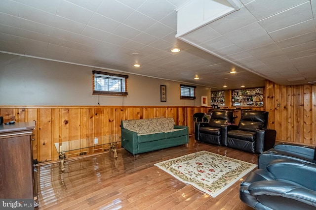 living room with hardwood / wood-style flooring and wooden walls