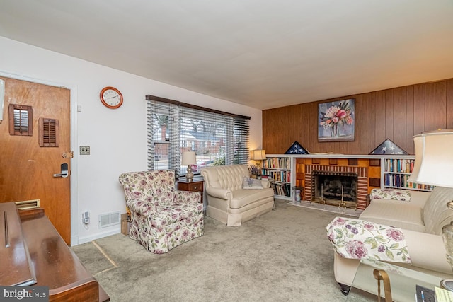 living room featuring a brick fireplace, carpet floors, and wood walls