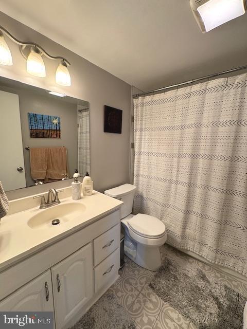 bathroom with vanity, tile patterned floors, and toilet