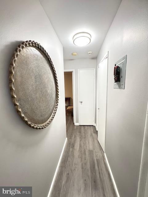 corridor with hardwood / wood-style flooring