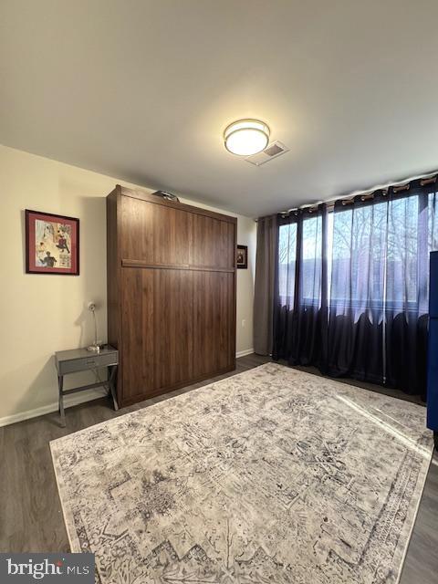 bedroom with dark hardwood / wood-style floors