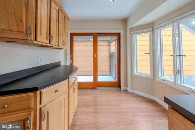 kitchen with a healthy amount of sunlight, light wood-type flooring, and french doors