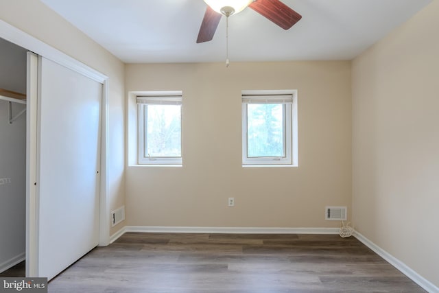 unfurnished bedroom with ceiling fan, light wood-type flooring, and a closet