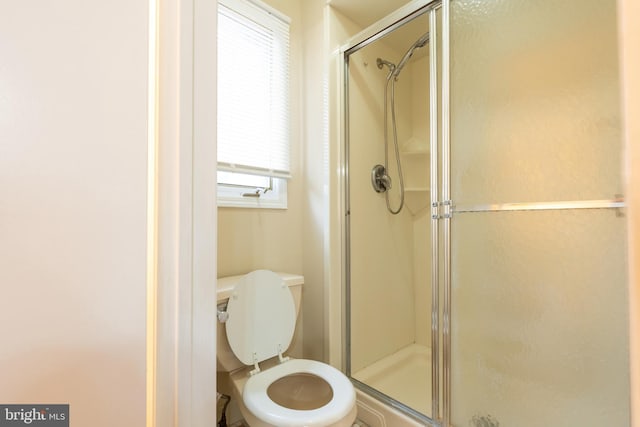 bathroom with an enclosed shower and toilet