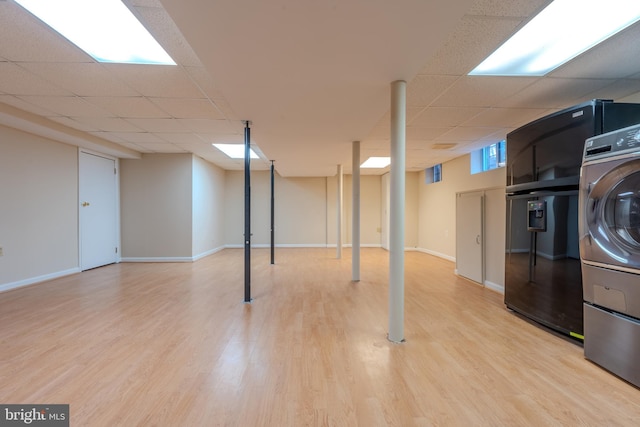 basement with washer / dryer, light hardwood / wood-style floors, and a drop ceiling