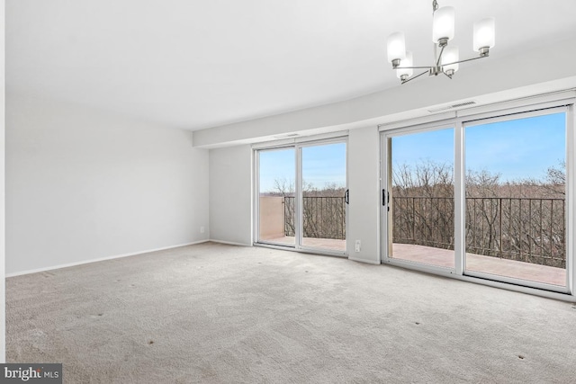 unfurnished room with carpet and a chandelier