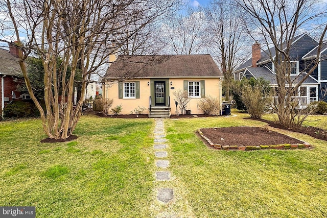 view of front of house featuring stucco siding, roof with shingles, and a front yard