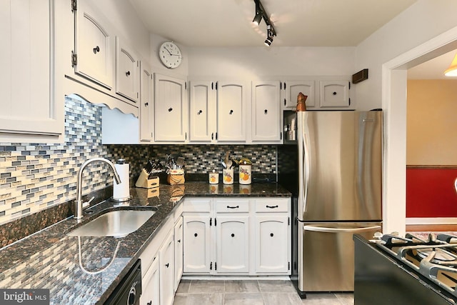 kitchen with white cabinets, freestanding refrigerator, and a sink