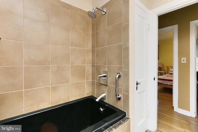 full bathroom featuring tiled shower / bath combo and wood finished floors