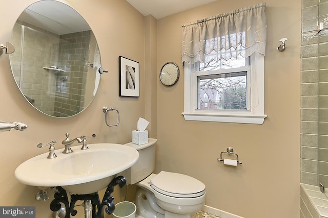 full bathroom featuring walk in shower, toilet, and a sink