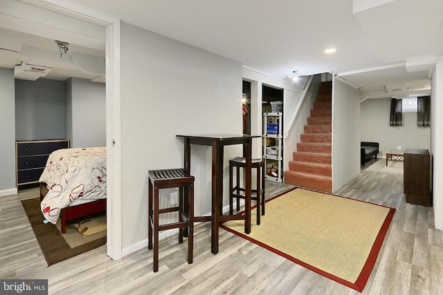 interior space featuring recessed lighting, stairs, baseboards, and wood finished floors