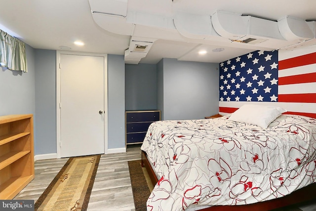 bedroom with visible vents, baseboards, and wood finished floors