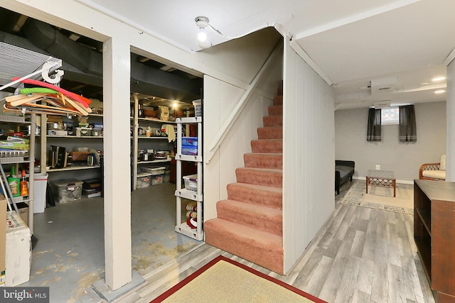 finished basement featuring wood finished floors and stairs