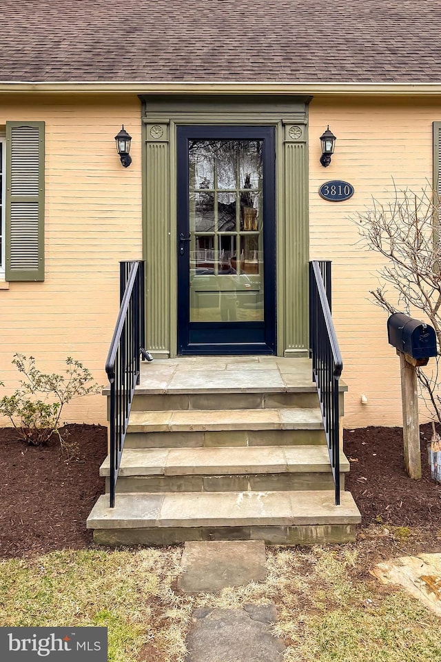 entrance to property with roof with shingles