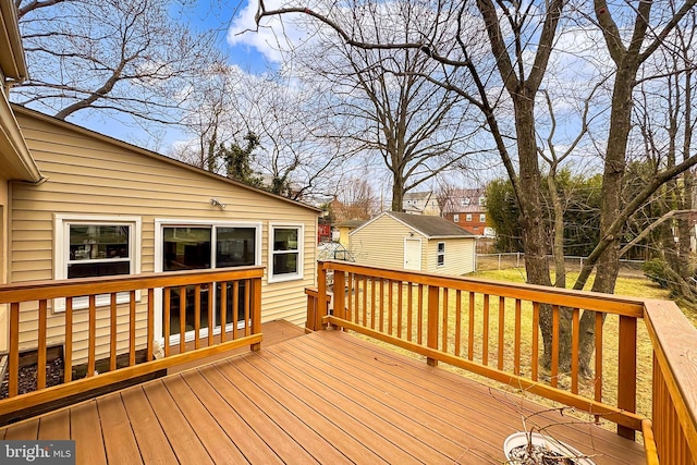 wooden deck featuring an outbuilding and fence