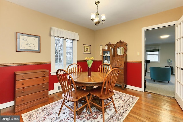 dining room with plenty of natural light, an inviting chandelier, and wood finished floors