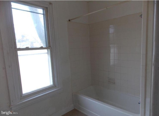 bathroom with tiled shower / bath combo and a healthy amount of sunlight