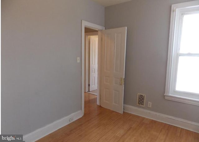 spare room with light hardwood / wood-style flooring and a healthy amount of sunlight