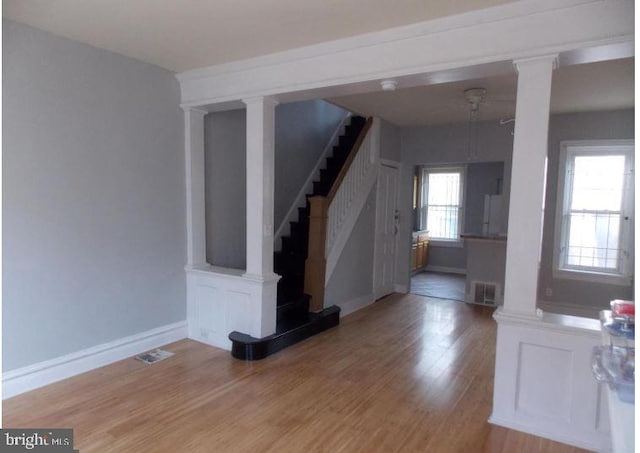 interior space featuring hardwood / wood-style flooring and decorative columns