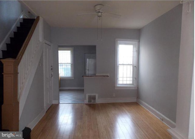 unfurnished living room with ceiling fan, a healthy amount of sunlight, and light hardwood / wood-style flooring