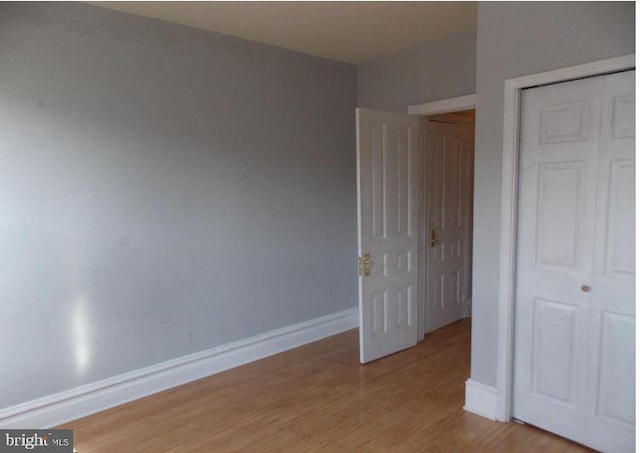 unfurnished bedroom featuring light hardwood / wood-style floors and a closet