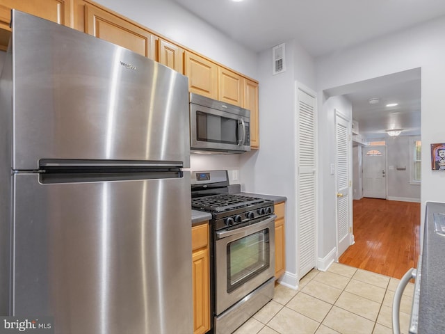 kitchen featuring light tile patterned flooring, stainless steel appliances, and light brown cabinets