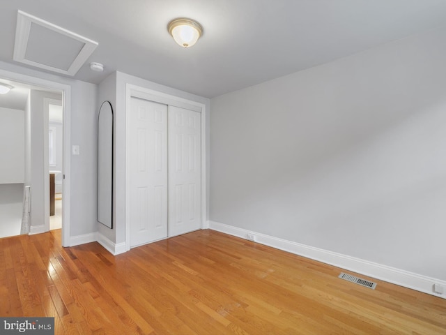 unfurnished bedroom with hardwood / wood-style flooring and a closet