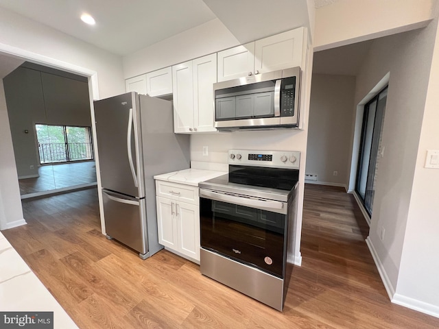 kitchen with white cabinetry, light hardwood / wood-style floors, and appliances with stainless steel finishes