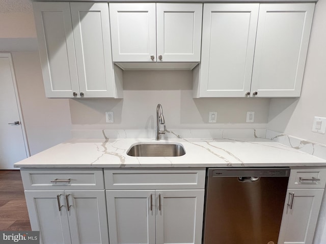 kitchen featuring sink, dark hardwood / wood-style floors, light stone countertops, white cabinets, and stainless steel dishwasher