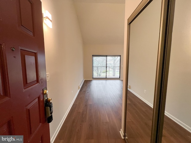 interior space with dark hardwood / wood-style flooring, vaulted ceiling, and baseboard heating