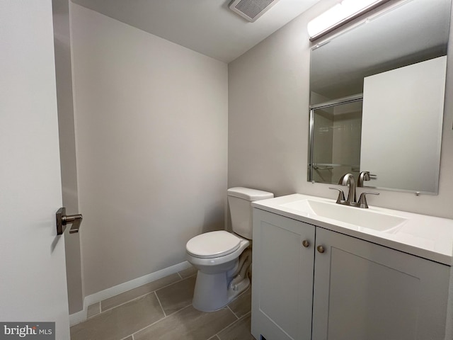 bathroom with tile patterned floors, vanity, toilet, and a shower with shower door