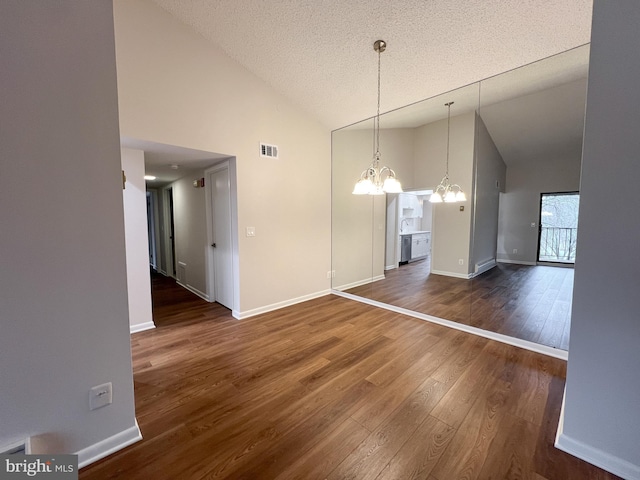 unfurnished dining area with an inviting chandelier, dark wood-type flooring, high vaulted ceiling, and a textured ceiling