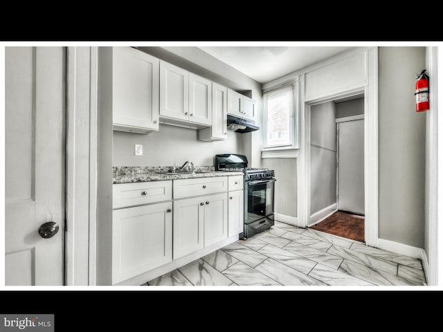 kitchen with sink, light stone countertops, gas stove, and white cabinets