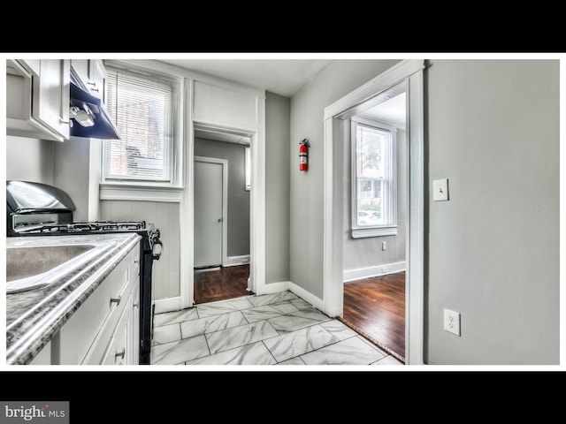 kitchen with white cabinetry and black gas range oven