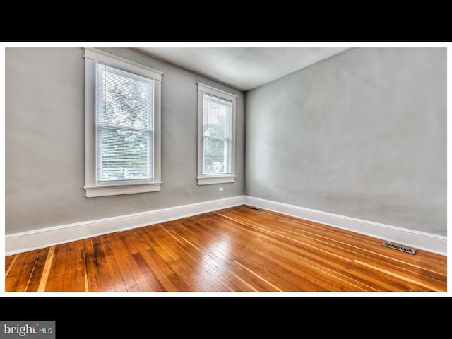 unfurnished room with wood-type flooring