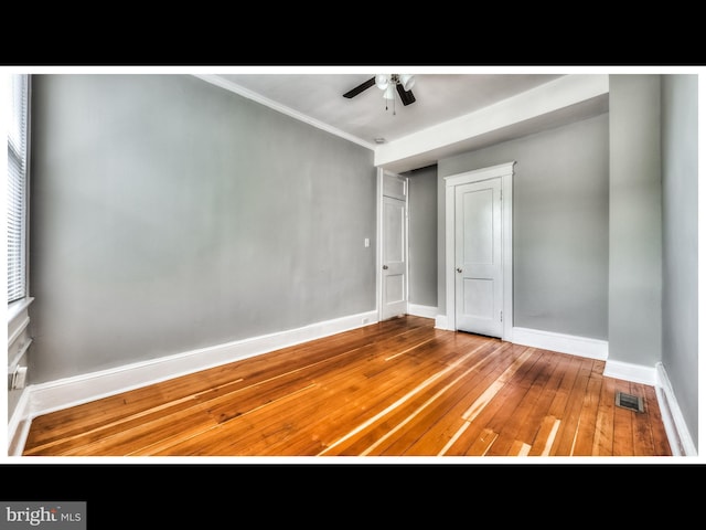 unfurnished bedroom featuring hardwood / wood-style floors, ornamental molding, a closet, and ceiling fan