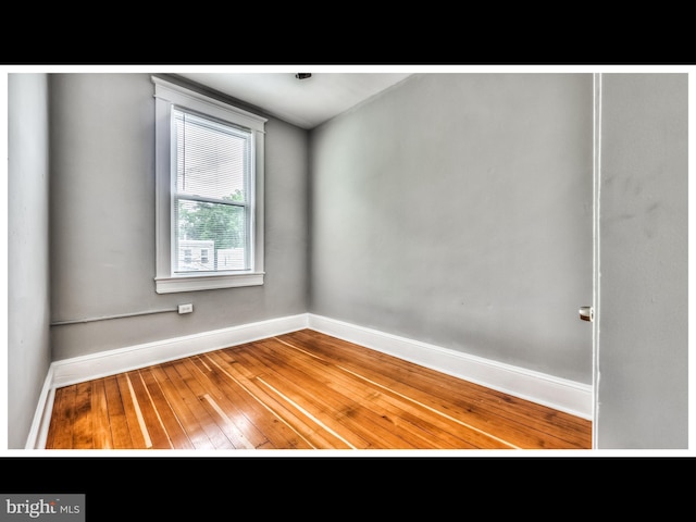 unfurnished room with wood-type flooring