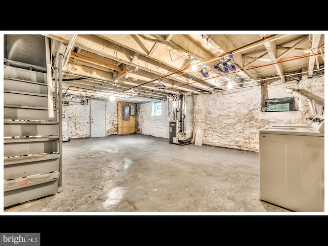 basement featuring separate washer and dryer, gas water heater, electric panel, and heating unit